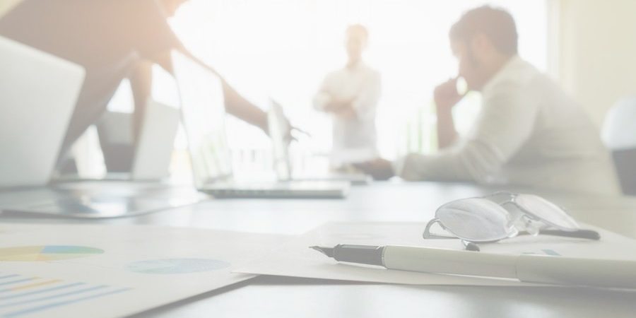 Business concept with copy space. Office desk table with pen focus and analysis chart, computer, notebook, cup of coffee on desk.Vintage tone Retro filter, selective focus. fiscal ecommerce