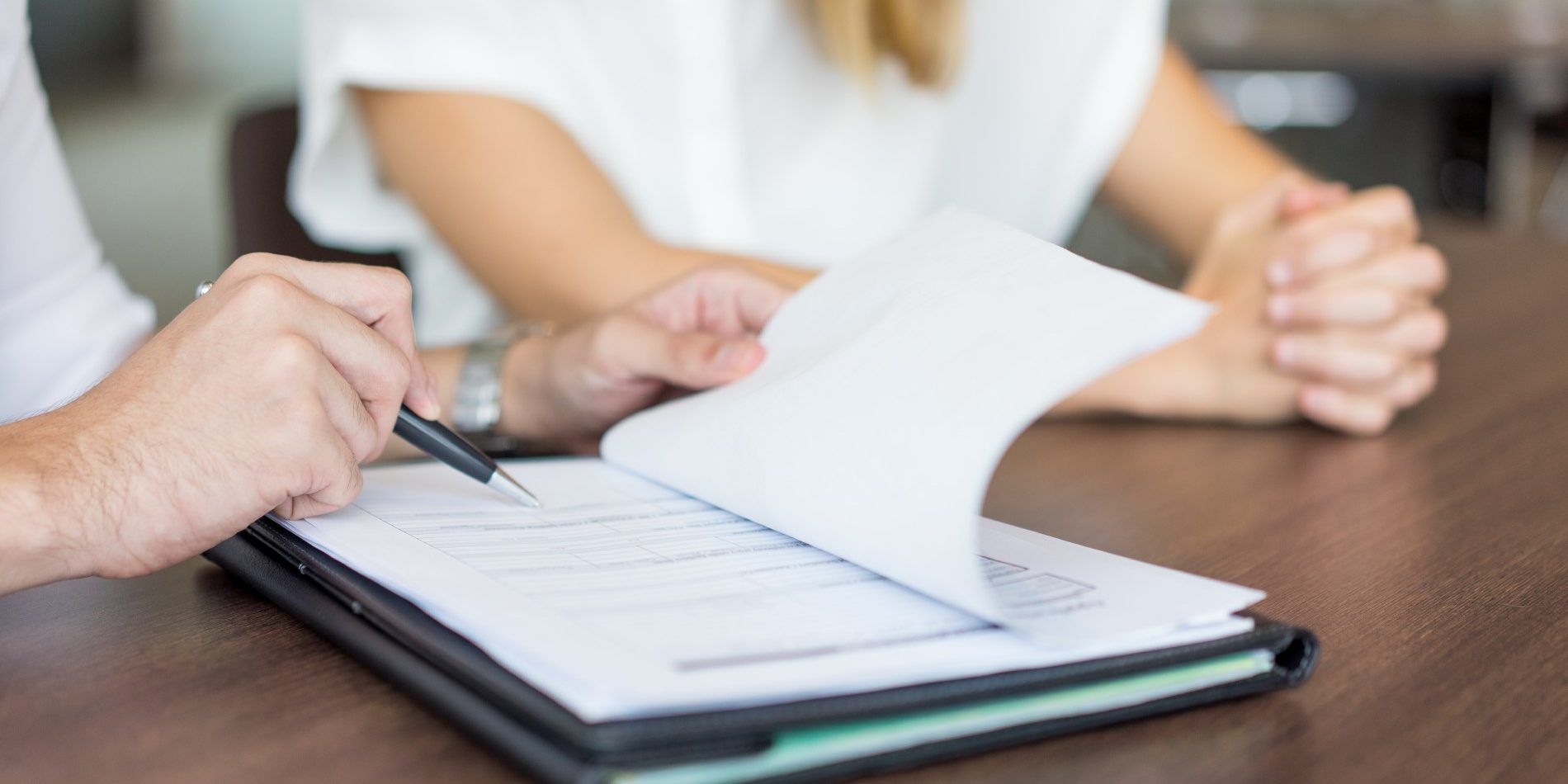 Hands of male executive showing contract to female partner nomina